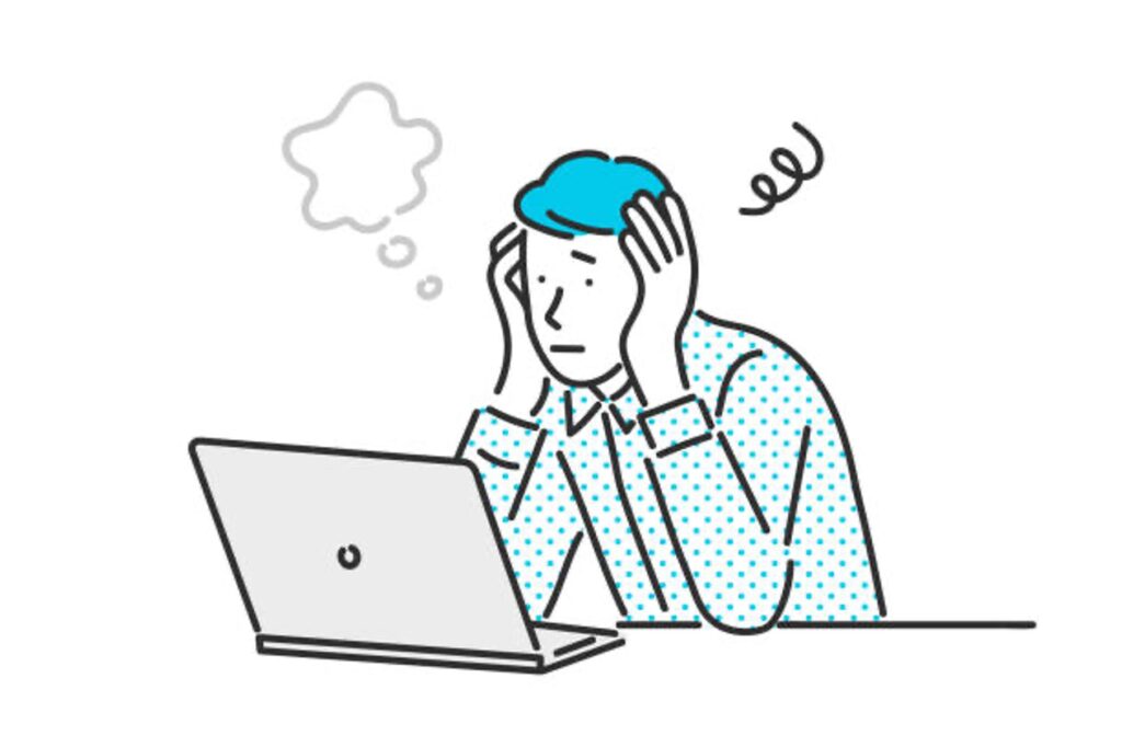 PCを前に頭を抱える従業員の画像